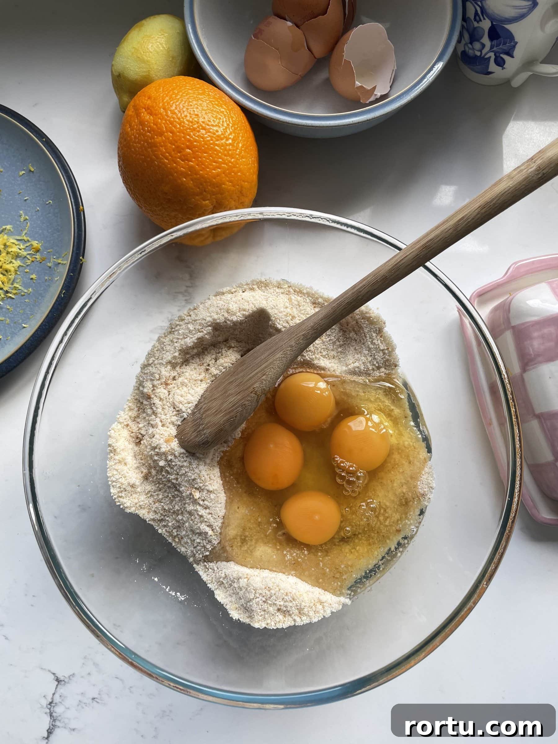 Ballymaloe Tunisian Orange Cake Recipe — Gluten-Free Version 6 Adding eggs in the glass mixing bowl.