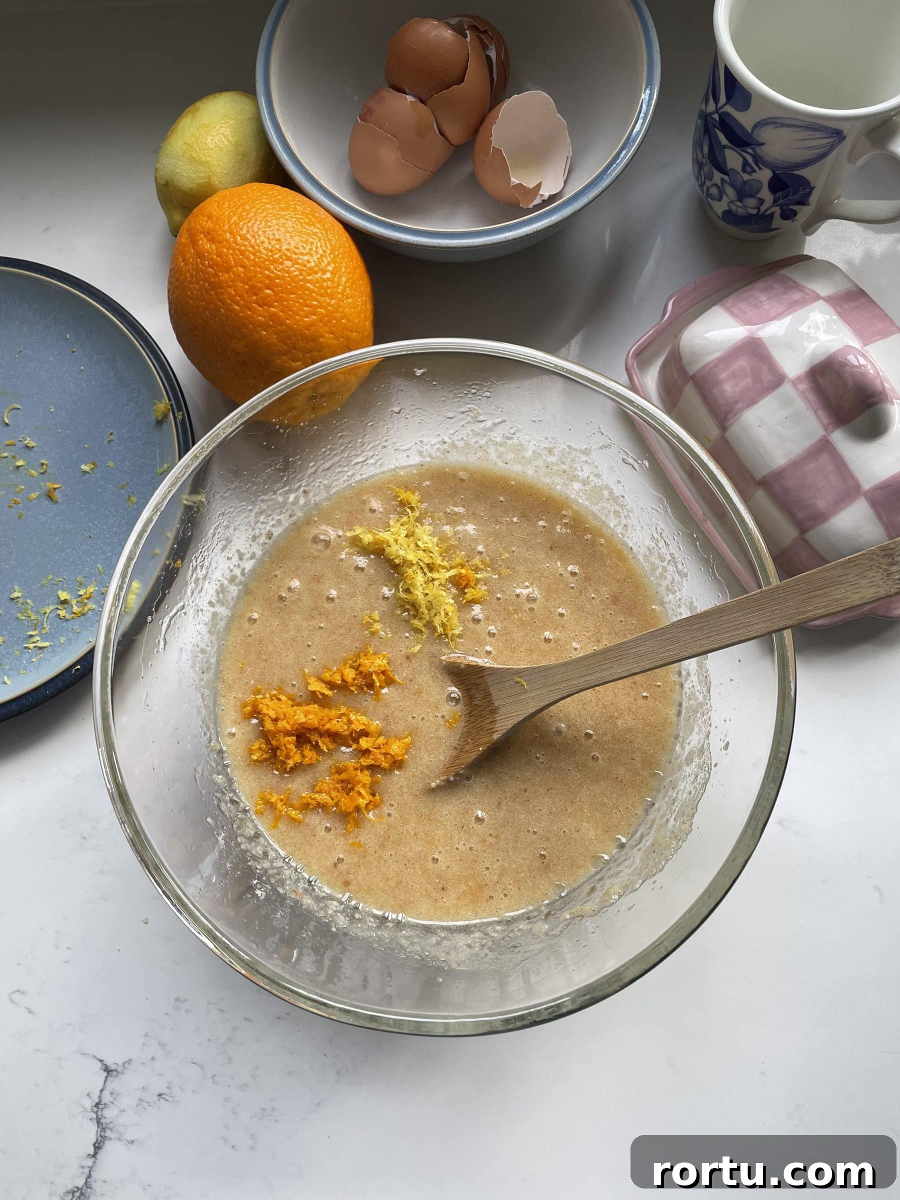 Ballymaloe Tunisian Orange Cake Recipe — Gluten-Free Version 7 Adding orange and lemon zest to the cake mix in the glass mixing bowl.