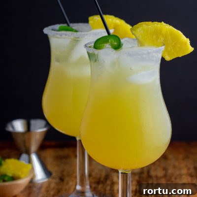 two glasses in cocktails with ice pineapple jalapeño