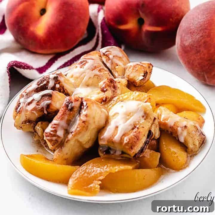 A serving of the cinnamon roll peach cobbler on a plate.