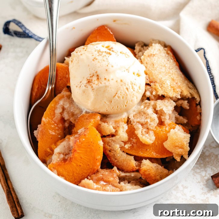 Old fashioned peach cobbler served warm with vanilla ice cream.