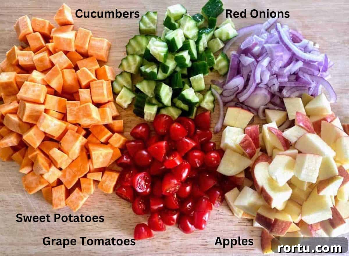 Fall harvest salad recipe ingredients: sweet potatoes, cucumbers, red onion,  apples and tomatoes. 