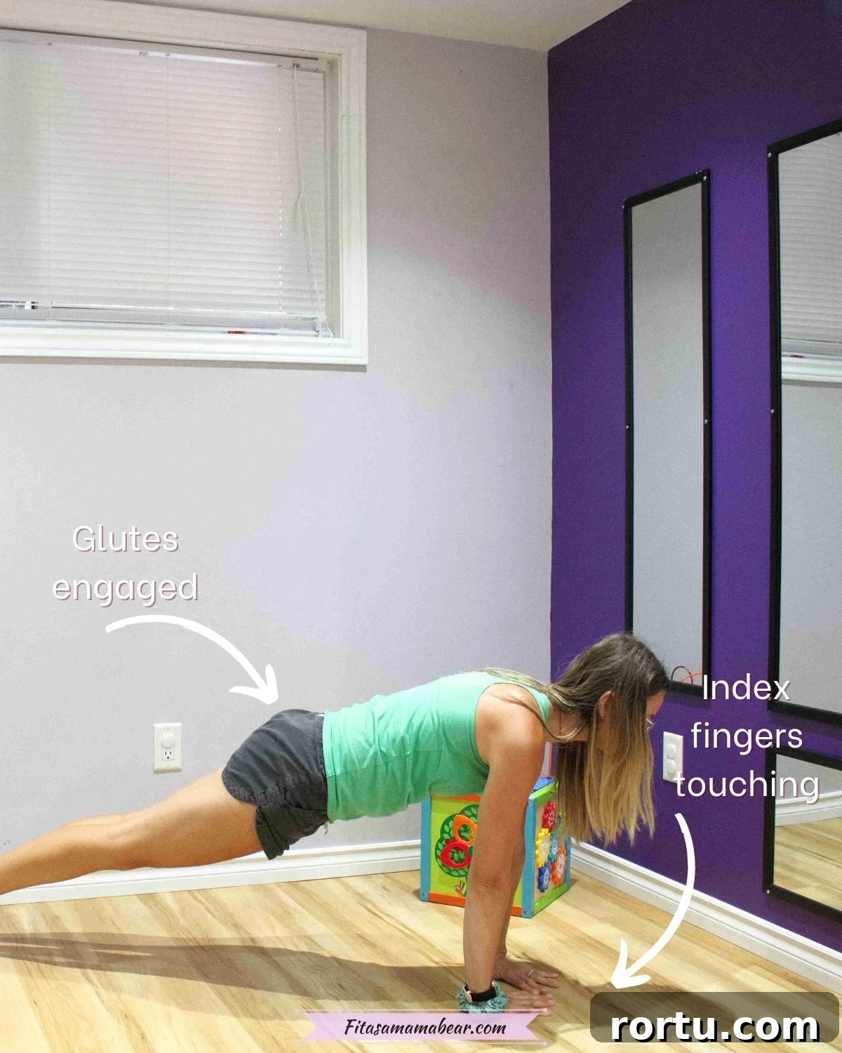 10 Targeted Exercises for Bat Wings + a 10-Minute Arm Routine 9 Woman in green shirt and black shorts in a plank position but her index fingers touching so her elbows are out wider