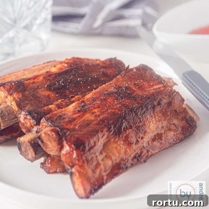 A square photo of a plate with a stack of honey kecap whisky ribs.