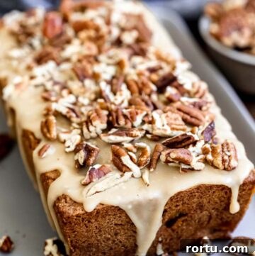 whole apple cinnamon bread with praline glaze and crushed pecans on top