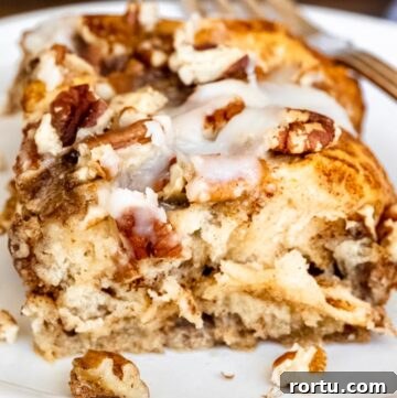 a slice of cinnamon roll casserole drizzled with icing