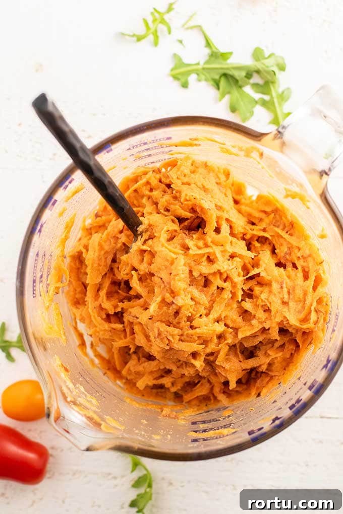 A large measuring cup with the batter for sweet potato waffles.