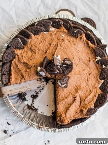 chocolate pudding pie with a slice removed, garnished with crushed oreos
