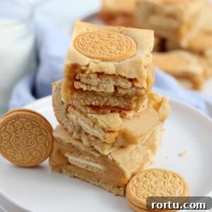 pile of golden oreo blondies on white plate with oreo cookies around