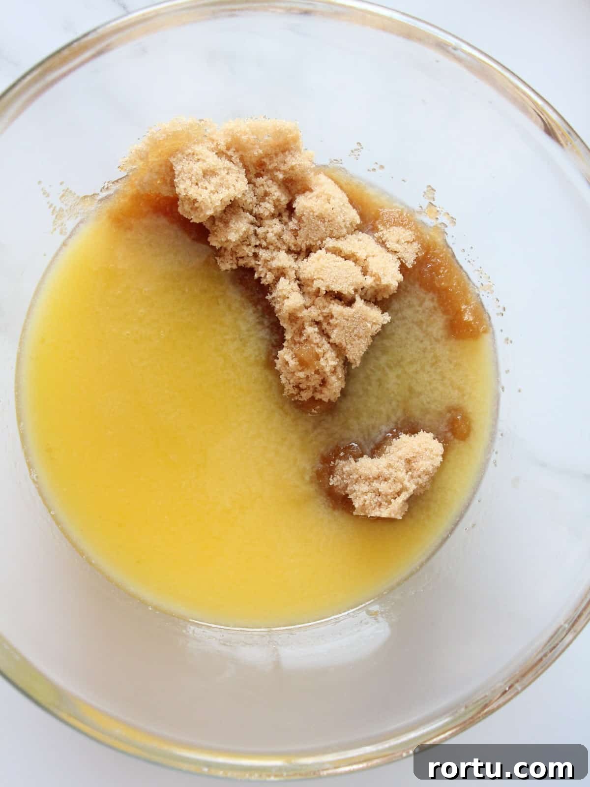 Melted butter with light brown sugar inside transparent kitchen bowl