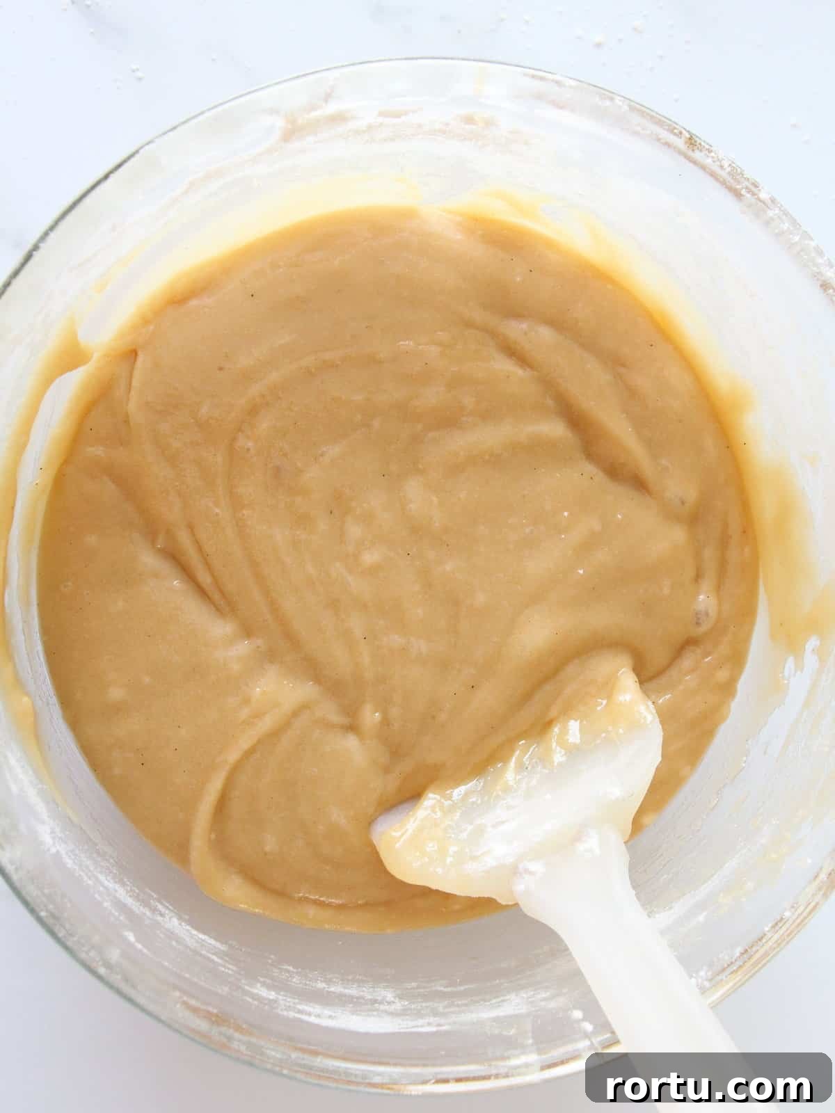 Fresh batter for blondies inside transparent kitchen bowl and spatula inside
