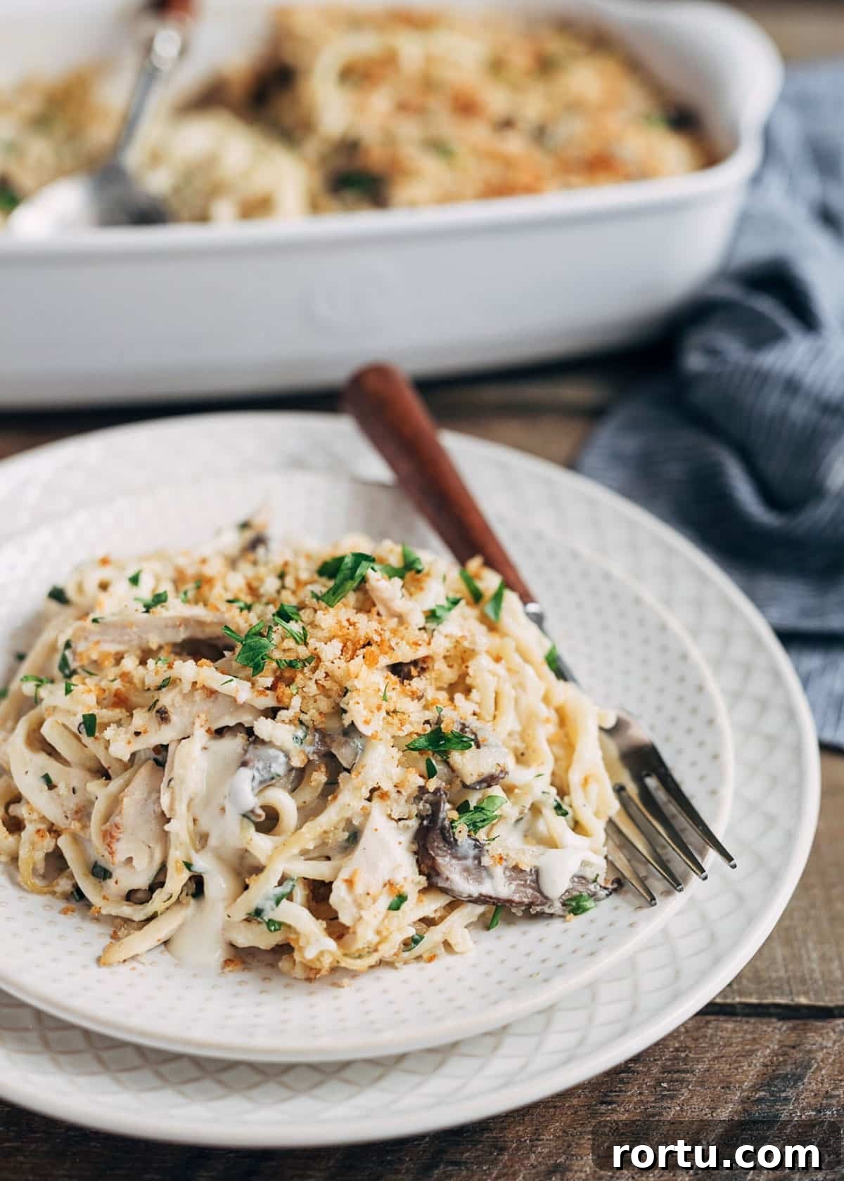 turkey tetrazzini on an ivory plate with a wood-handled fork