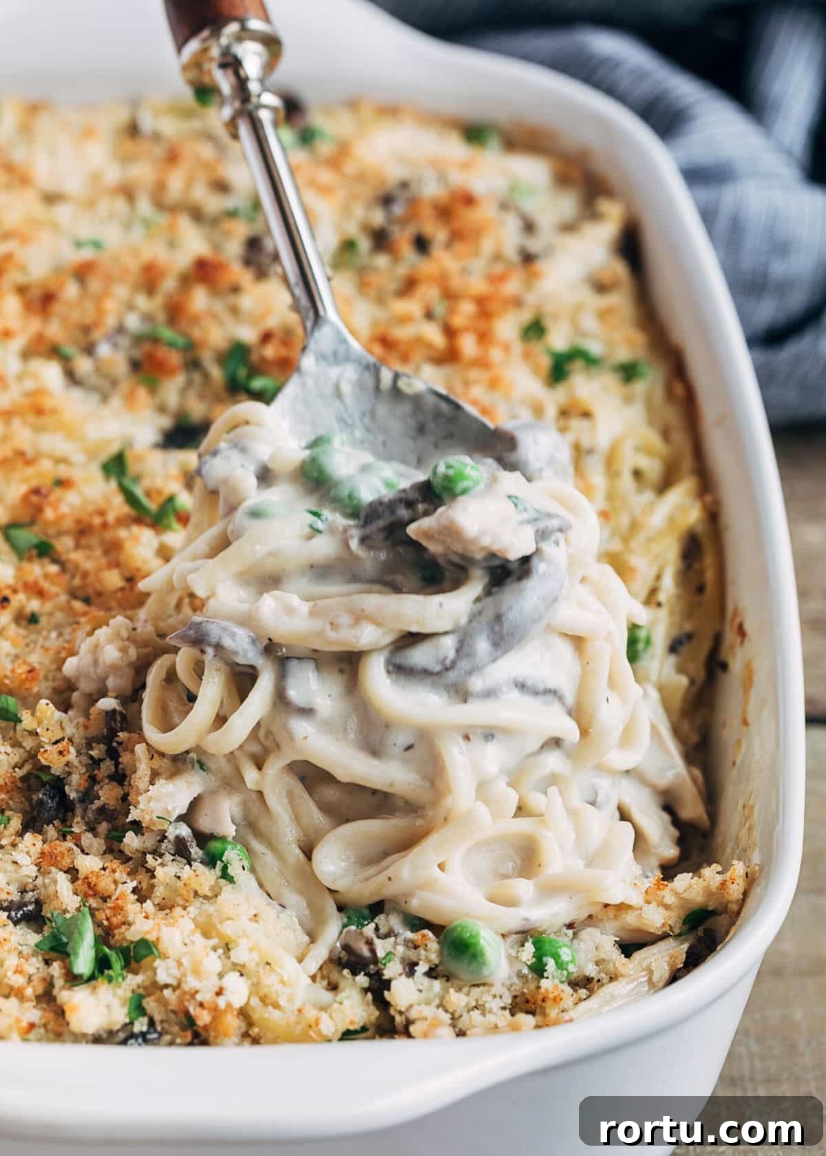 baked turkey tetrazzini being scooped from a white baking dish