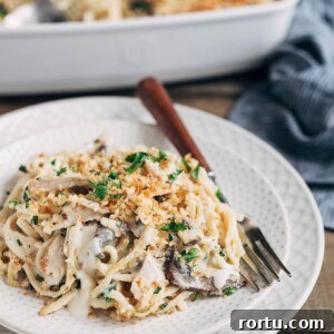 turkey tetrazzini on an ivory plate with a wood-handled fork