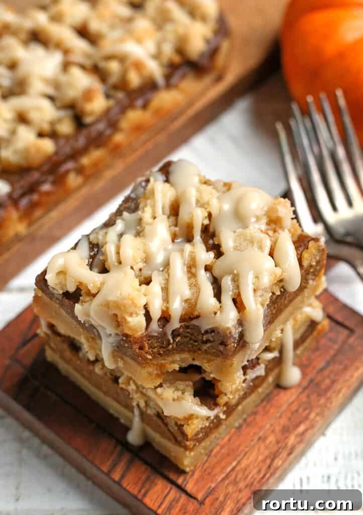 Paleo Vegan Pumpkin Crumble Bars for Fall Baking 4 stack of paleo pumpkin bars with a bite out of the top one