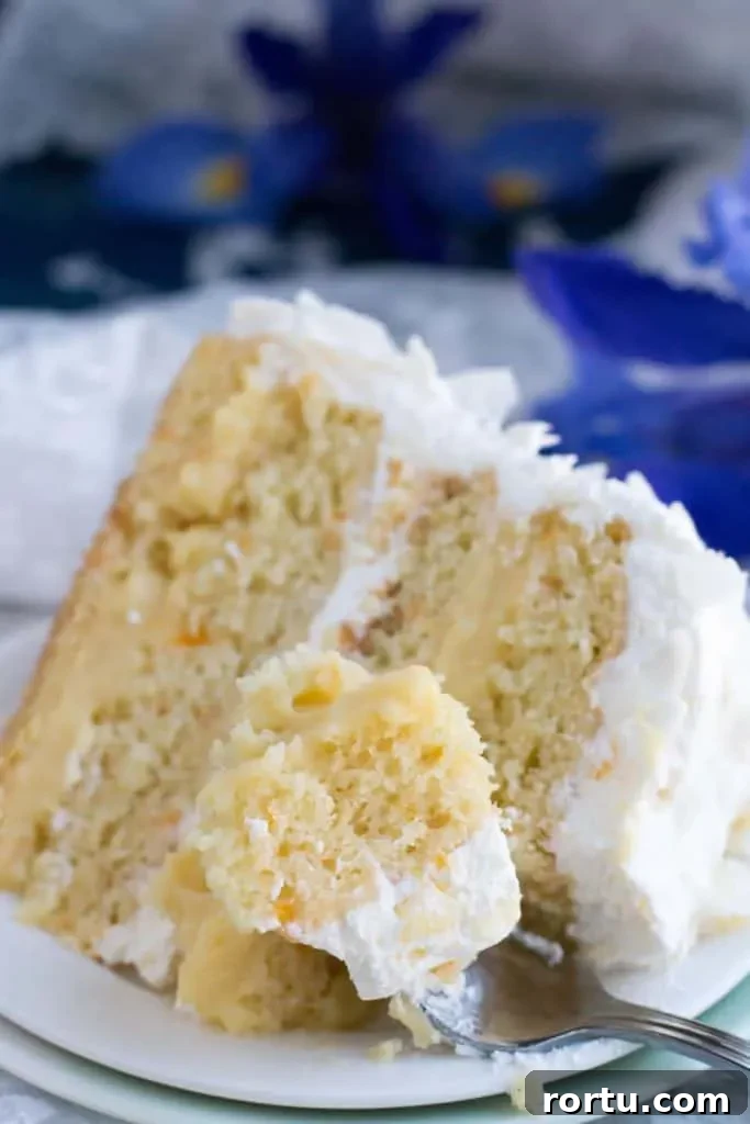 Mandarin Orange Pineapple Cream Cake. Layers of mandarin orange cake, filled with pineapple coconut pastry cream and covered in pineapple whipped cream and coconut chips. Perfect for Easter or Spring gatherings.