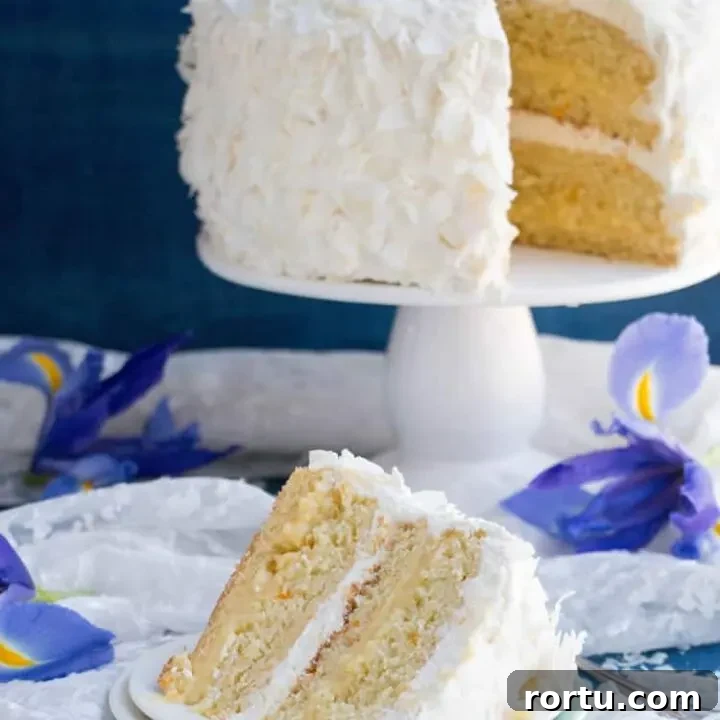 Mandarin Orange Pineapple Cream Cake. Layers of mandarin orange cake, filled with pineapple coconut pastry cream and covered in pineapple whipped cream and coconut chips. Perfect for Easter or Spring gatherings.