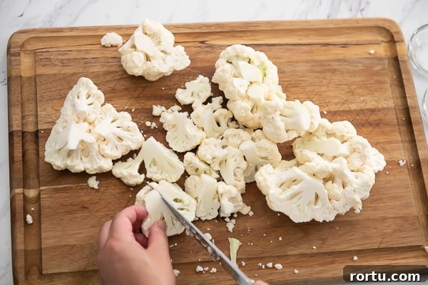 Cauliflower being cut on a board