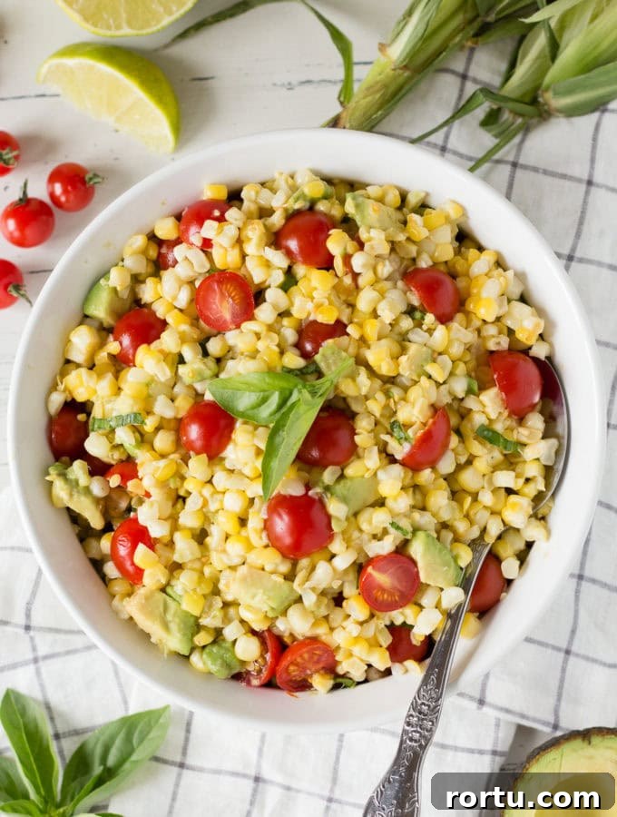 corn tomato avocado salad in a white bowl