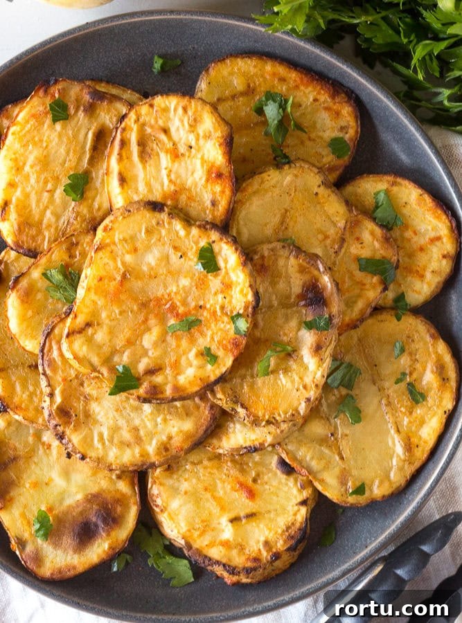 Top down view of grilled potatoes stacked on a gray plate.