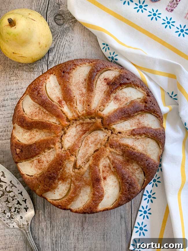 Olive Oil Pear Cake with Ginger and Cinnamon 6 A whole pear cake with pear, cake server, striped napkin.