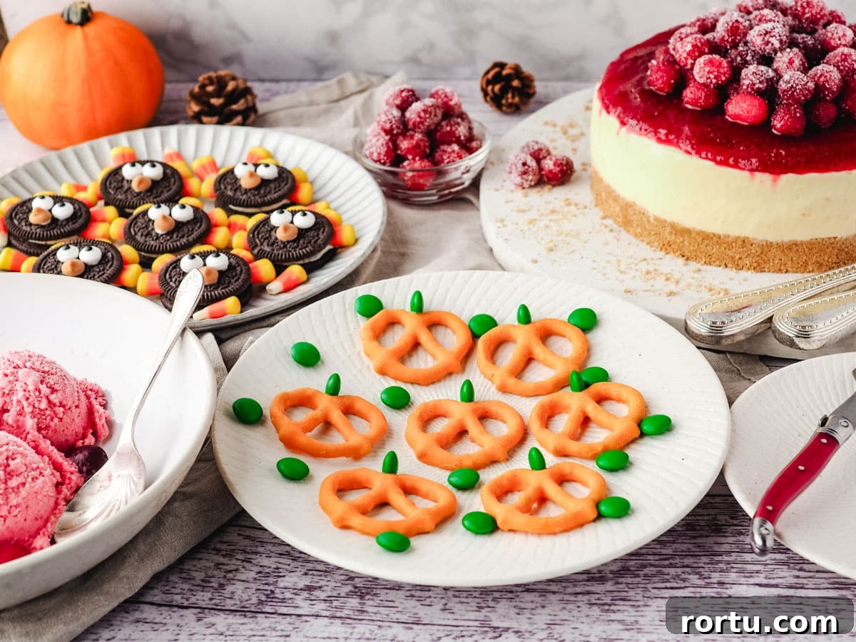 Pumpkin pretzels on a serving plate, on a Thanksgiving dessert table to cranberry cheesecake, turkey Oreos and cranberry ice cream.