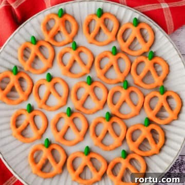 Pumpkin pretzels on a plate with a fall tea towel in the background.