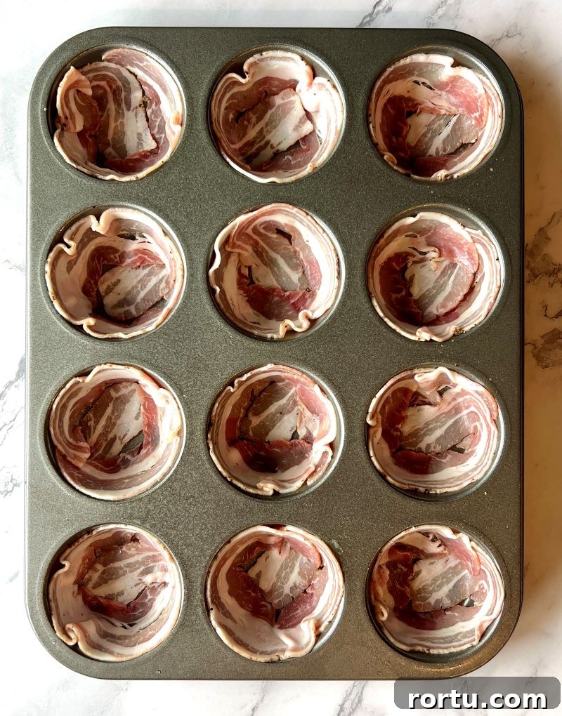 Muffin pan filled with each pancetta round, forming a cup shape