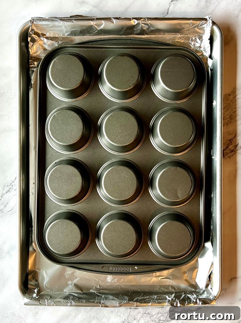 Muffin pans fitted together and turned upside down on sheet pan lined with foil.