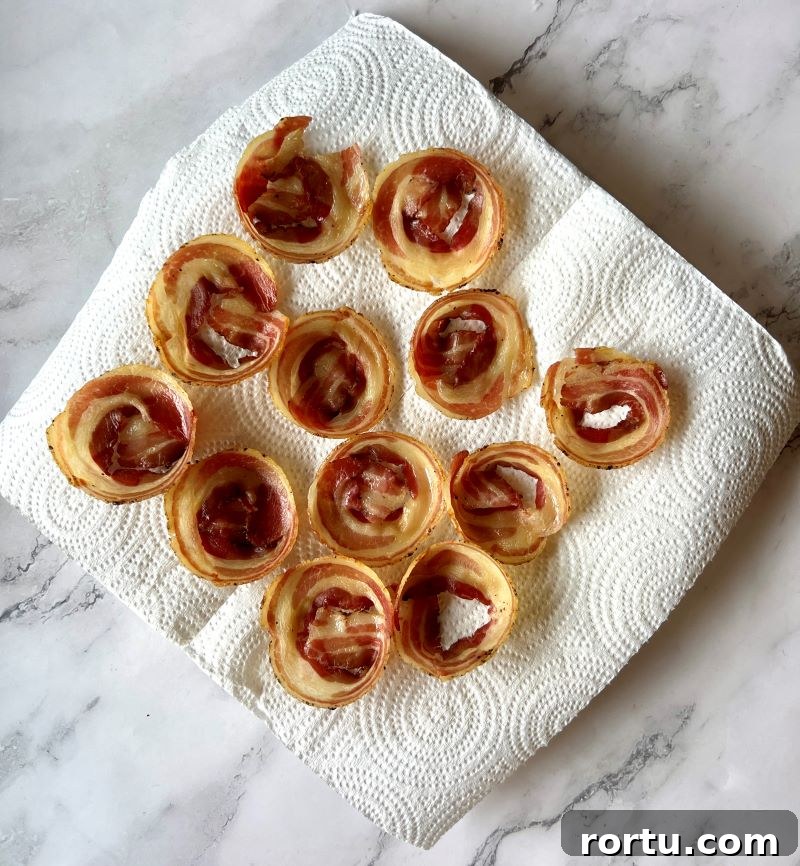 Pancetta cups resting on paper towels after they are baked.