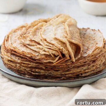 Freshly made basic crepes stacked high on a plate.