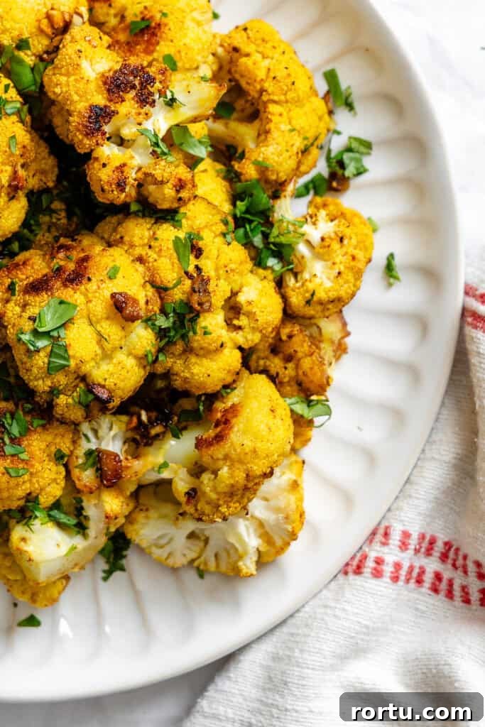 Curry-Roasted Cauliflower Recipe: Crispy Spiced Cauliflower Roast 2 Curry Roasted Cauliflower on white plate