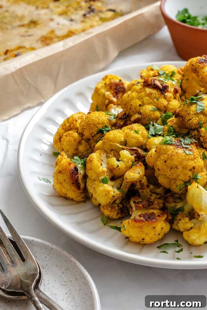 Curry-Roasted Cauliflower Recipe: Crispy Spiced Cauliflower Roast 9 Curry Roasted Cauliflower with cilantro on plate