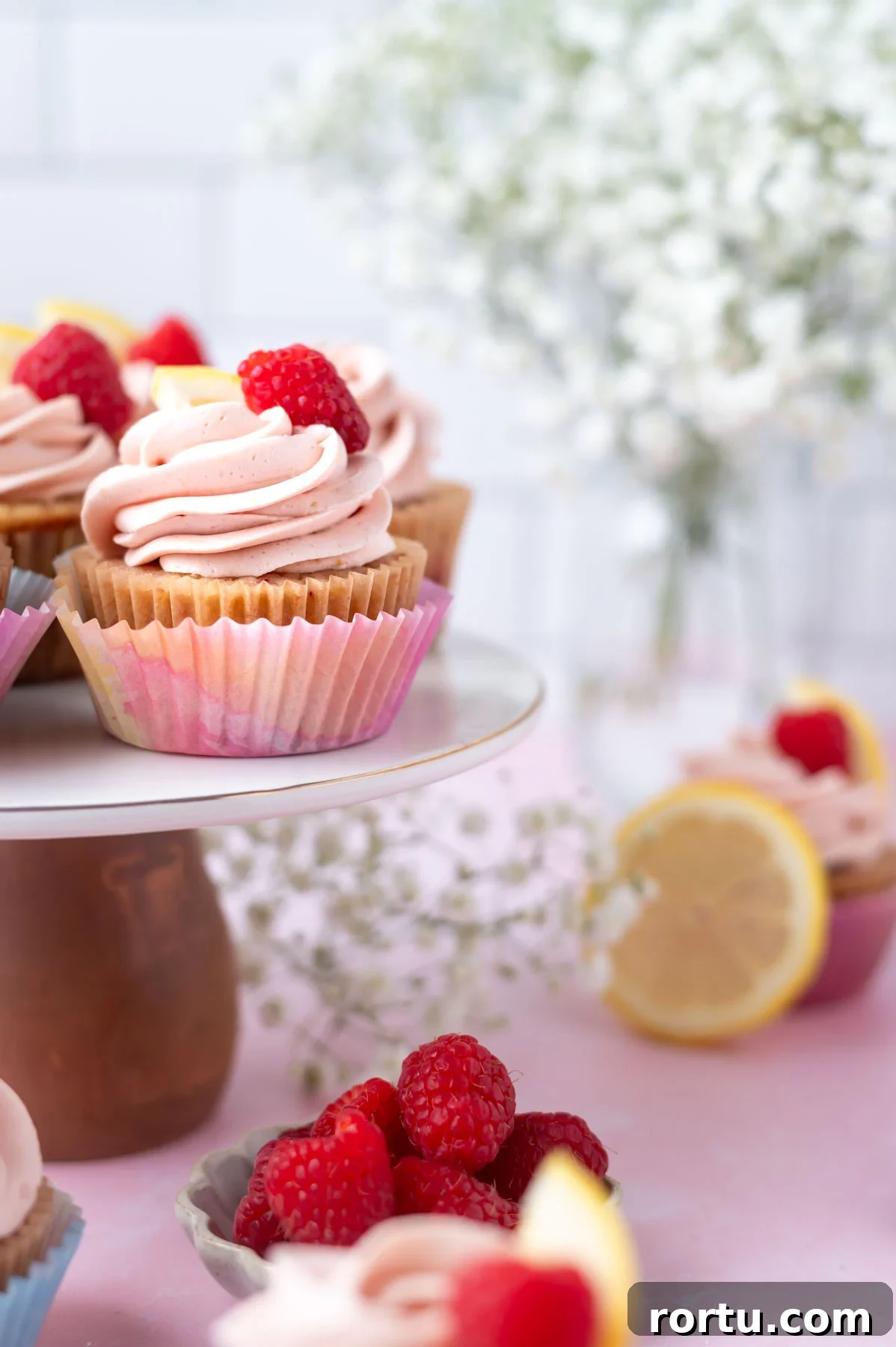 Lemon Raspberry Cupcakes Made from Scratch: Bright Summer Recipe 11 cupcakes on a cake stand with flowers in the background