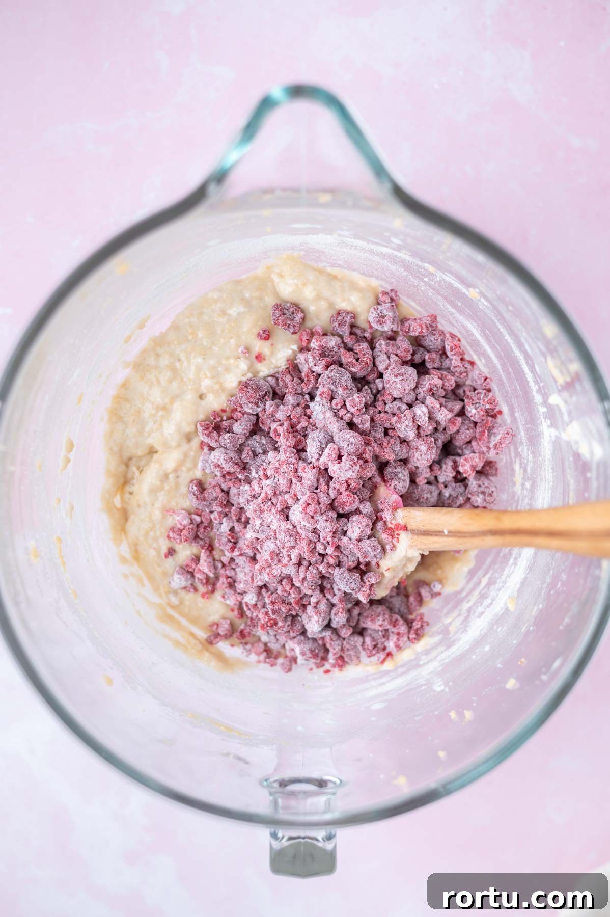 Lemon Raspberry Cupcakes Made from Scratch: Bright Summer Recipe 7 frozen raspberries tossed with flour on top of lemon cupcake batter in a bowl with a spatula
