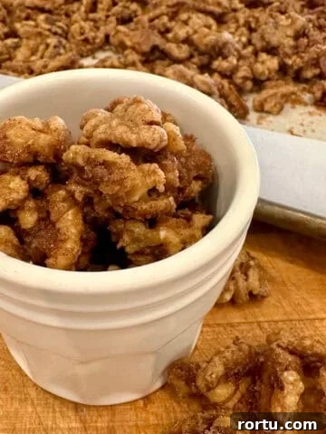 Close-up of spiced walnuts roasted with cinnamon and sugar in a jar.