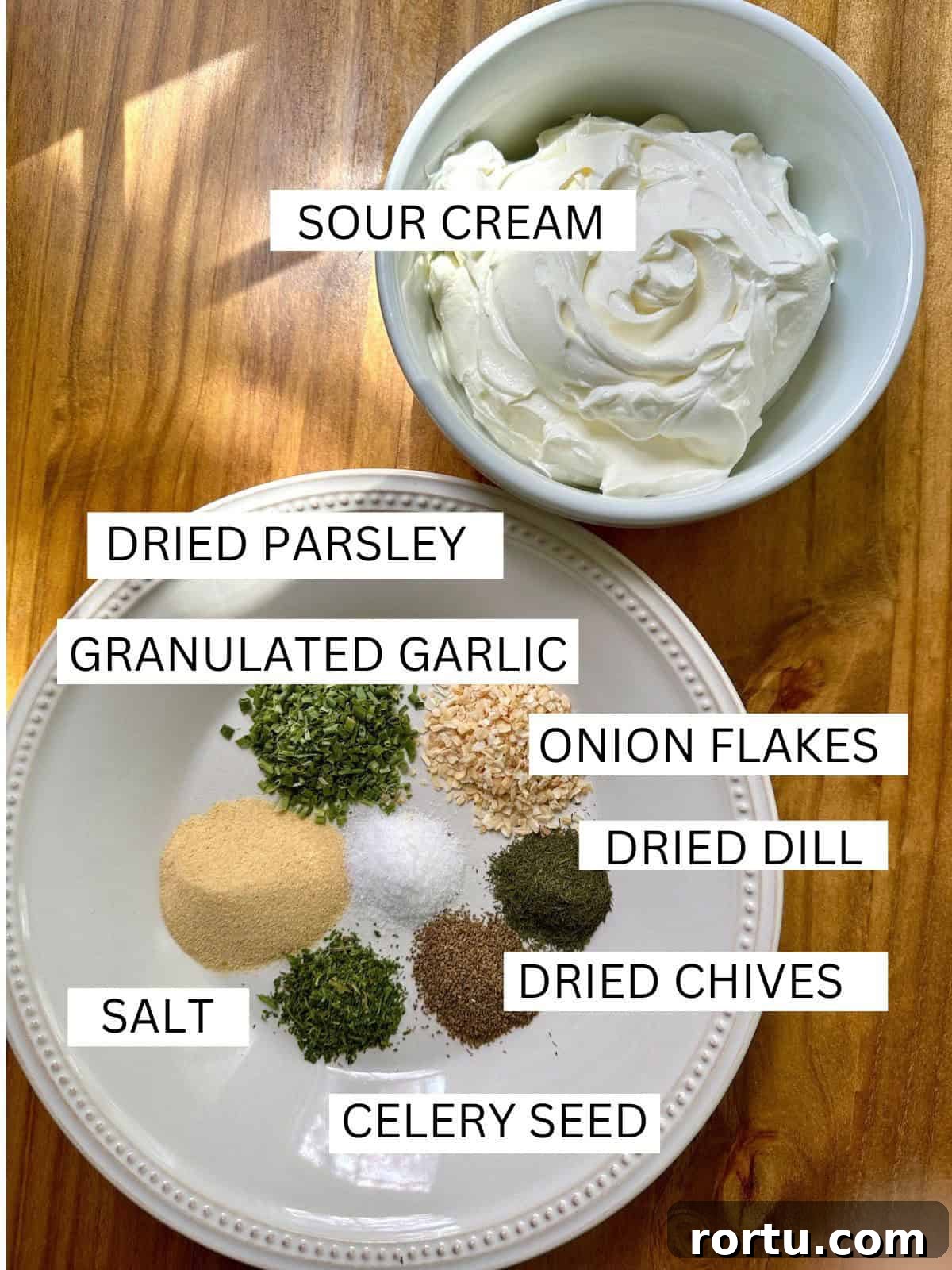 Ingredients for herb and garlic dip with labels on a table.