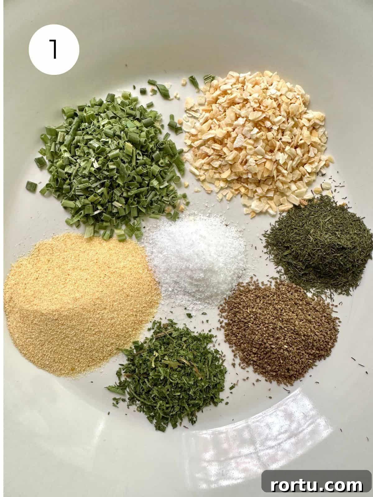 Dried herbs and salt in small mounds on a plate.