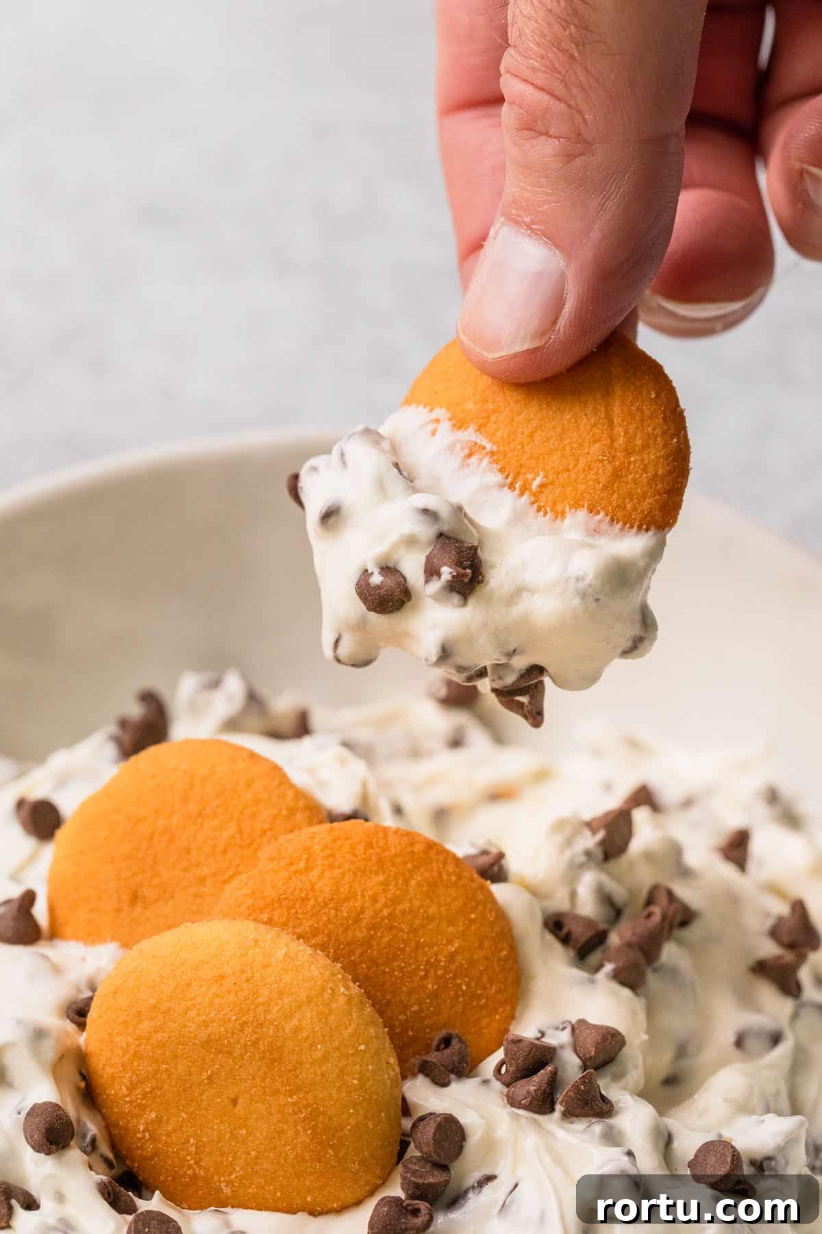 Viral TikTok Booty Dip Recipe: Step-by-Step Guide for Parties 8 a vanilla wafer dipping into the completed booty dip recipe