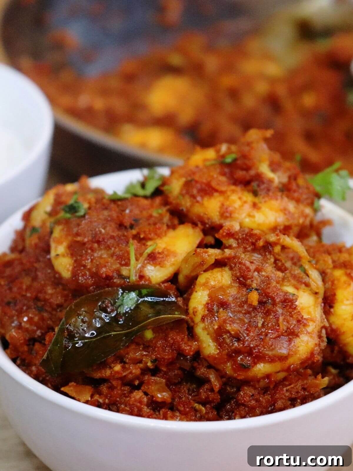 close-up of prawn sukka served in a white bowl.