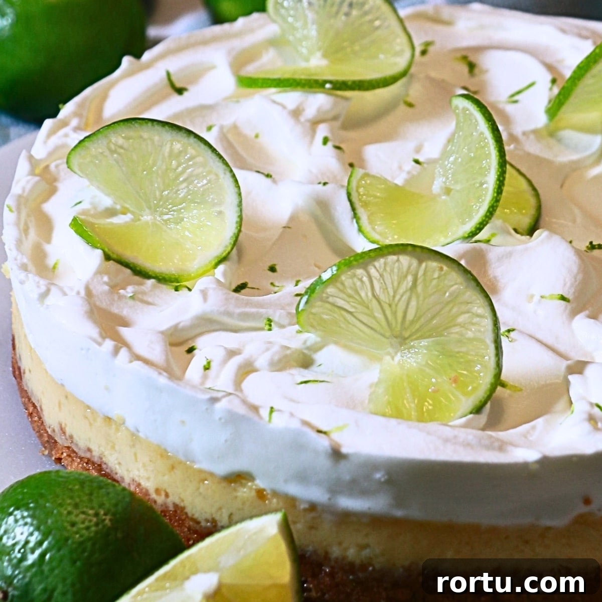 a whole key lime pie decorated with slices of a lime
