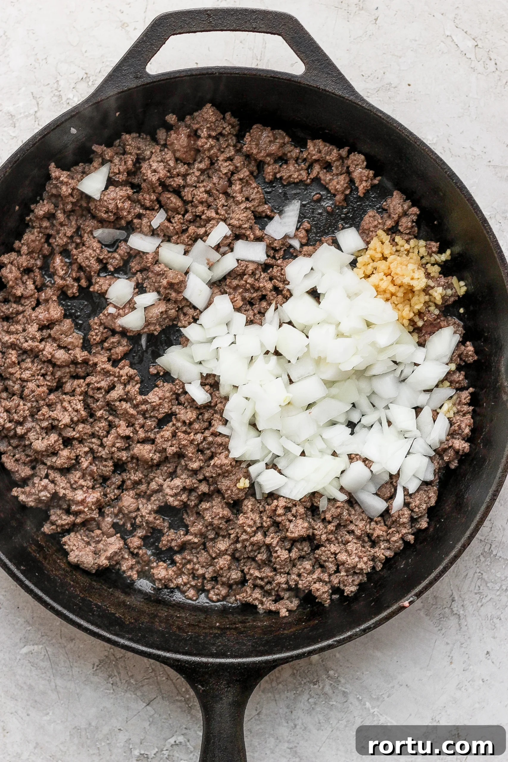 Ground beef and onions ground beef and diced onions in a cast iron skillet