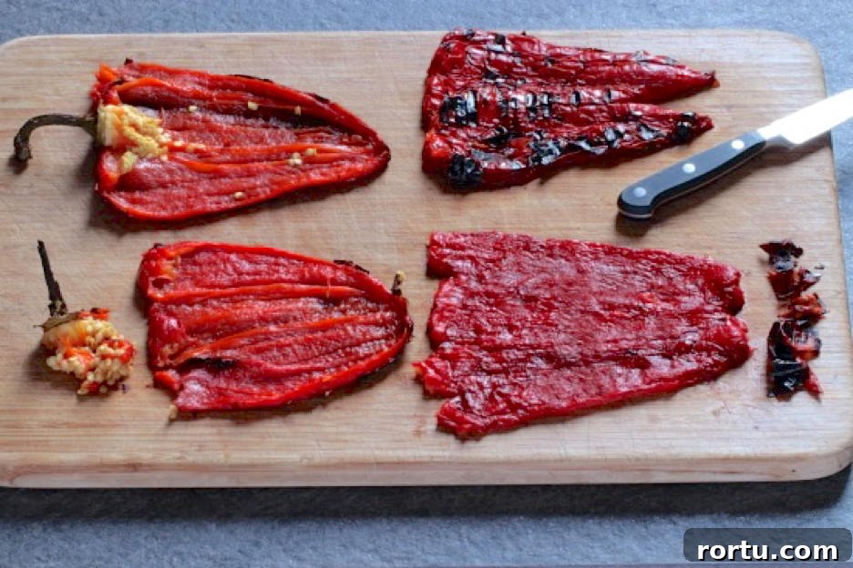 Roasted red peppers with seeds and stems removed laying on cutting board