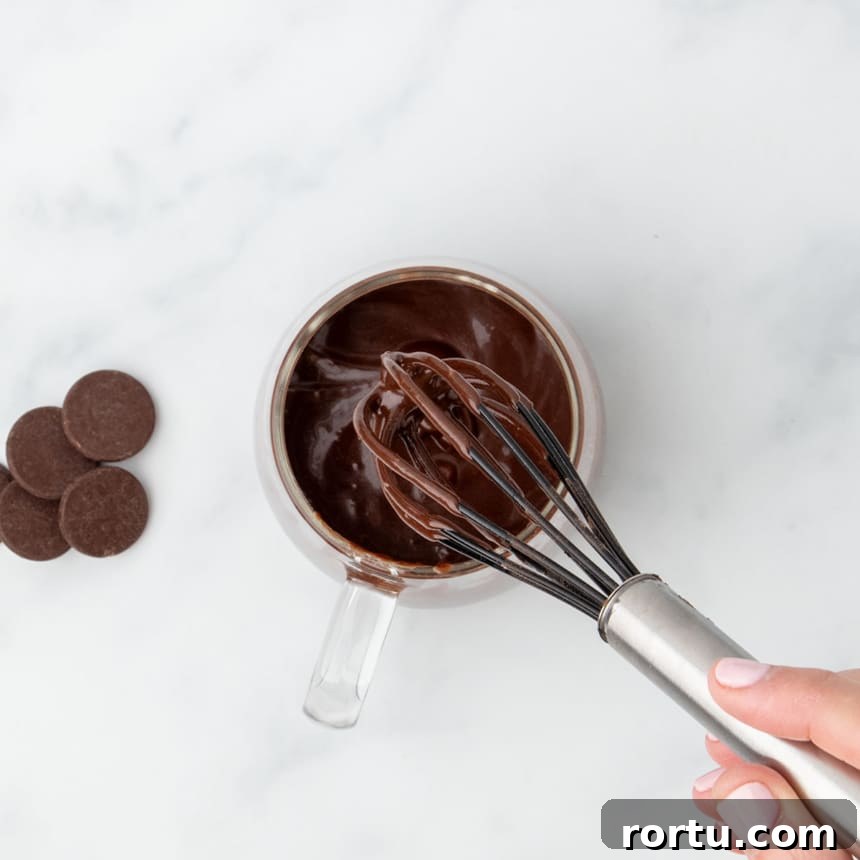 Chocolate batter being whisked until smooth inside the mug.