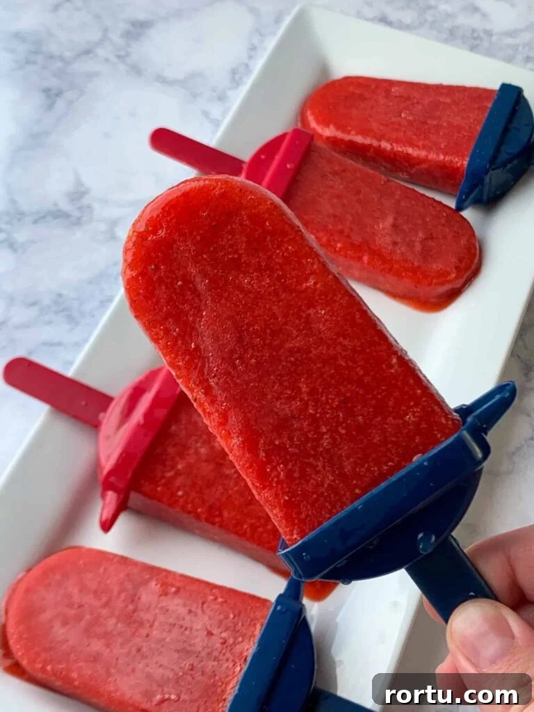 Easy homemade strawberry popsicles with red and blue handles