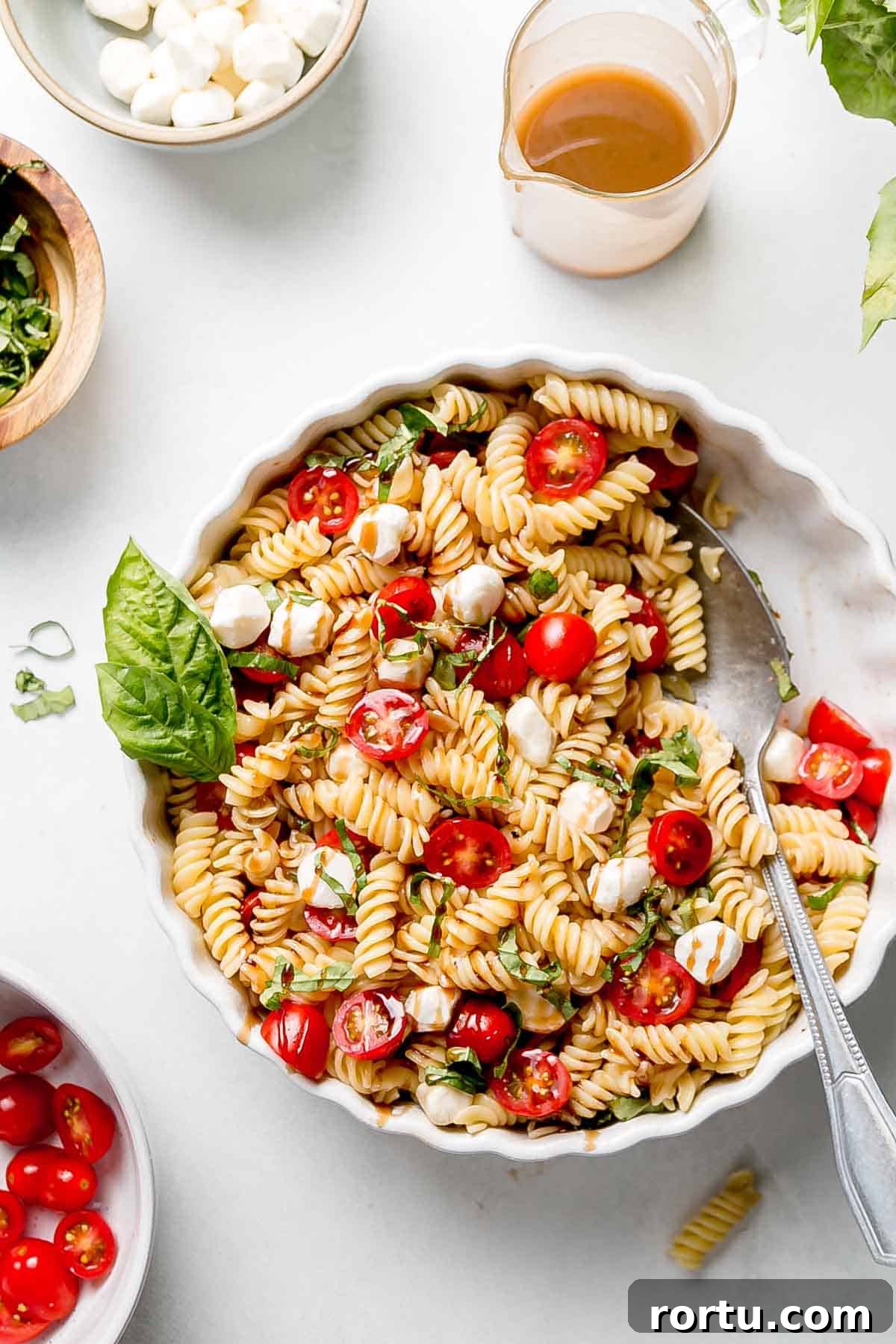 Gluten-free Caprese Pasta Salad in round white dish.