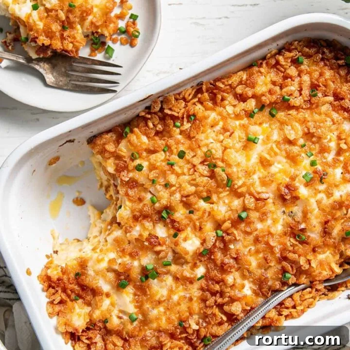 Gluten-free Hashbrown Casserole in a white dish, scoop removed on a plate.