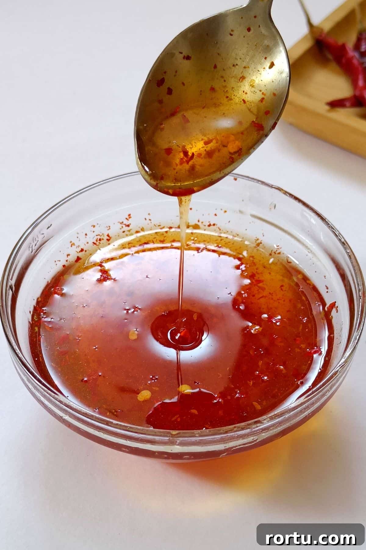 How to Make Homemade Hot Honey Sauce for Wings and Drizzle 2 Image showing hot honey sauce in a glass bowl.