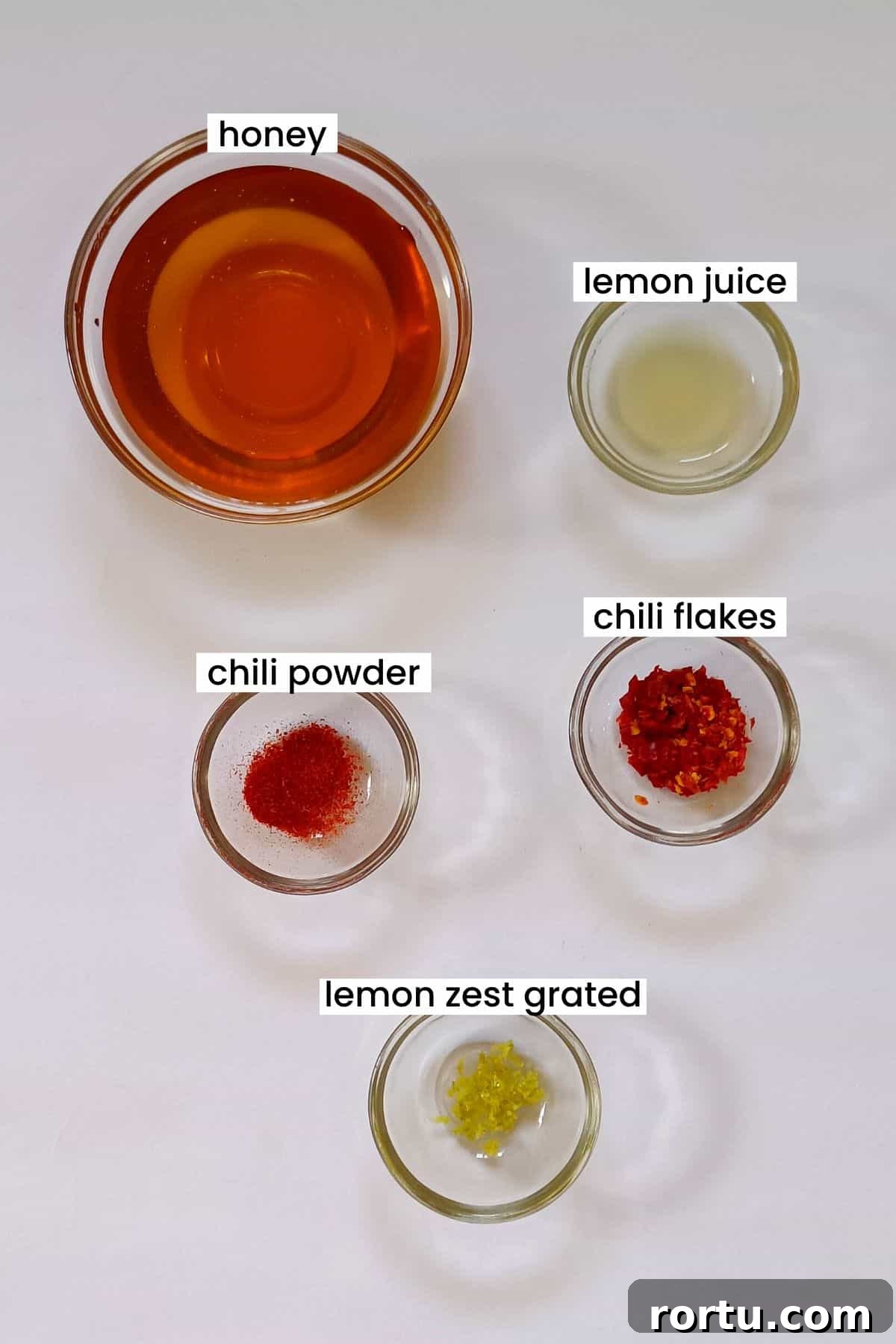 How to Make Homemade Hot Honey Sauce for Wings and Drizzle 3 Image showing hot honey ingredients are placed on a white background.