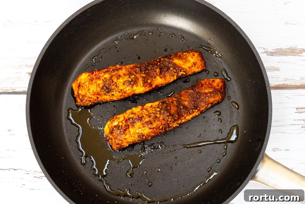 Moroccan-Spiced Salmon: Quick Midweek Dinner Recipe 5 salmon in a frying pan coated in ras el hanout spice blend